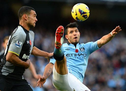 Manchester City's Sergio Aguero (R) vies with Tottenham Hotspur's Steven Caulker